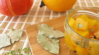 a canning jar of Sweet Pickled Squash garnished with bay leaves