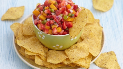 a bowl of Strawberry Salsa surrounded by corn chips