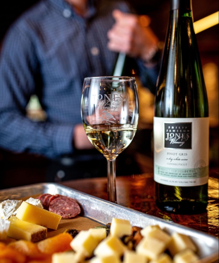 Wine glass and wine bottle with tray of cheese